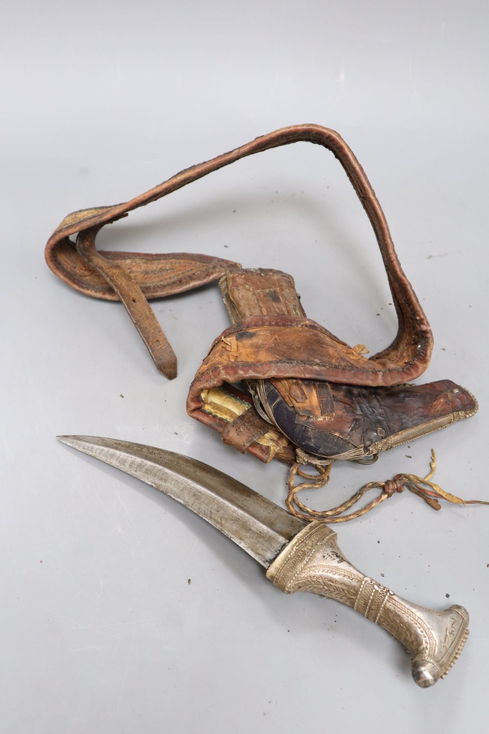 A silver-mounted Arab dagger jambiya with woven leather belt, length 30cm